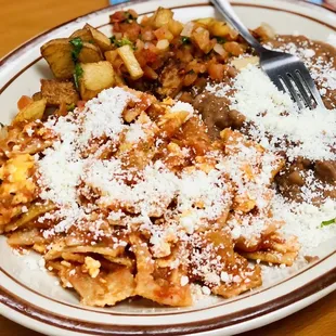 Red chilaquiles (scrambled egg mixed in) with potatoes, refried beans, and pico de gallo