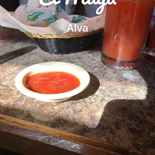 a bowl of tomato soup and a glass of orange juice