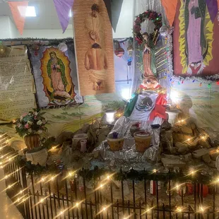 a statue of the virgin of guadalupe surrounded by lights