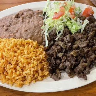Carne Asada Plate with refried rice, beans, and a side of lettuce &amp; tomato.