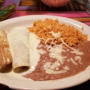Beef enchilada, beef tamale, rice and beans all topped with white queso.