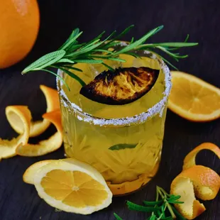 a cocktail with oranges and rosemary
