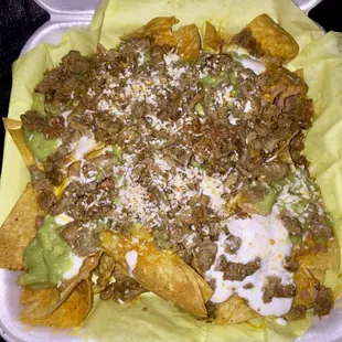 Super Nachos: Generous Portions of Carne Asada, Shredded Cheese, Refried Beans, Sour Cream, and Guacamole Atop Corn Chips - Well Made &amp; Yum!