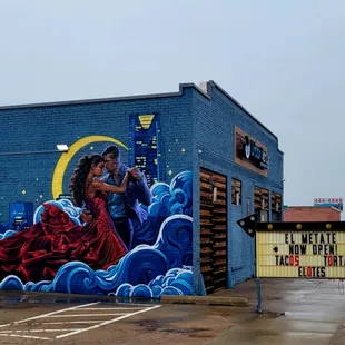 a mural of a man and a woman in a red dress