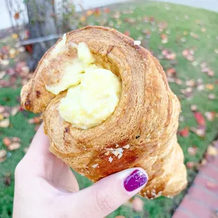 a hand holding a pastry with butter
