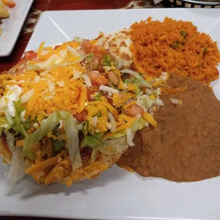 A lunch plate with a $2 upcharge for dinner - a tostada and a soft taco with beans and rice.