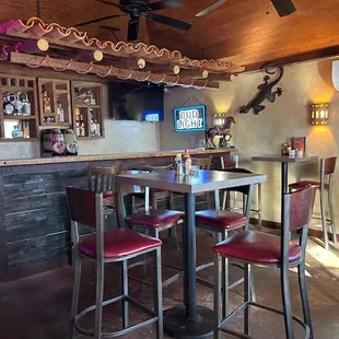 a bar with red chairs
