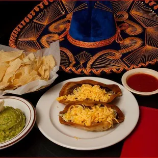 a plate of mexican food and a bowl of guacamole