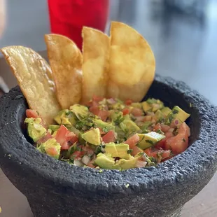 a bowl of guacamole and chips