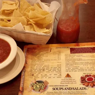a menu and a bowl of salsa