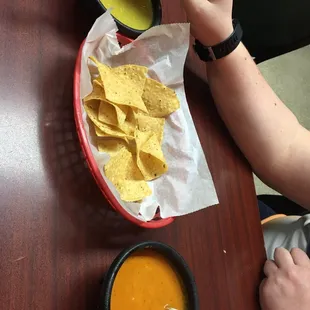 a person dipping a tortilla into a bowl