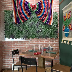  table and chairs in front of a brick wall