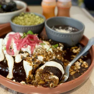 Enmoladas de Pollo: Chicken enchiladas w/ mole sauce, refried black beans, rice | $19