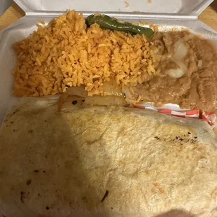 Beef steak burrito stuffed with all the fixins&apos;, side of rice and beans.