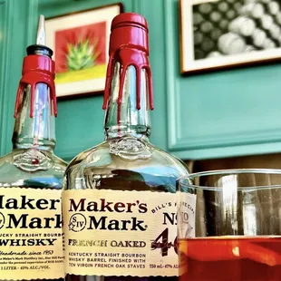 two bottles of maker&apos;s mark no 4 and a glass of whiskey