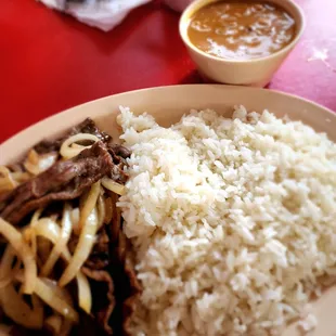 Bistek encebollado, arroz y habichuelas