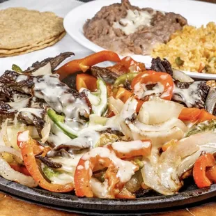 Alambre served with rice, beans, and tortillas