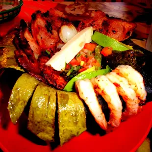 Molcajete filled w/ camerones, chuleta, chorizo, nopales, avocado, cambray, queso, &amp; fried jalapeno