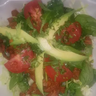 taco salad with al pastor, avocado, and spinach, tomato, and cheese.