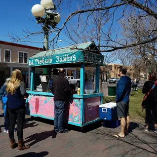 a group of people standing in front of a kiosk