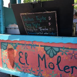 a woman standing in front of a food cart