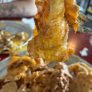 The slop held by a fork of the cheese crisp.