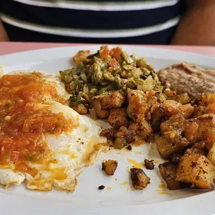 This plate is 2 eggs over easy with refried beans, papas con huevo y nopaliots with a combination of corn and flower tortilla.