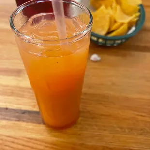 a glass of orange juice with a straw