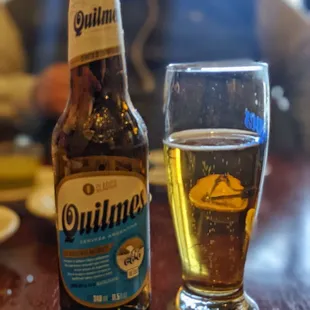 a bottle of quillinn and a glass of beer