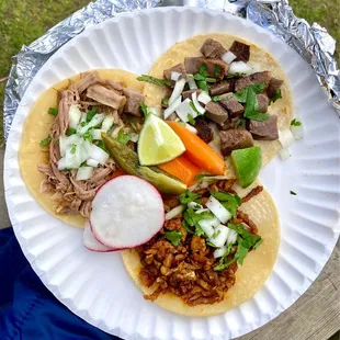 Clockwise from top right: lengua, carnitas, and adobada tacos