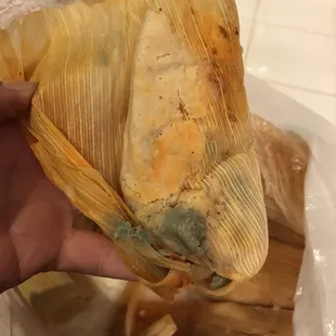 a person holding a tamales