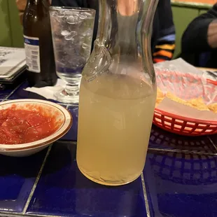 a pitcher of lemonade and a bowl of salsa