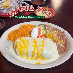 Chicken fajita Chimichanga, topped with sour cream sauce, served with rice and beans