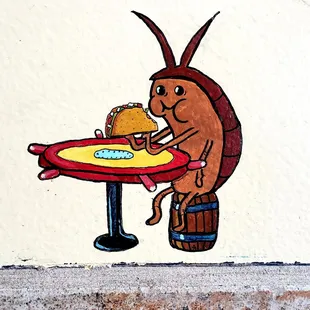 It&apos;s a tiny painting near the floor of a cockroach enjoying a taco. Very cute, random, and amusing.