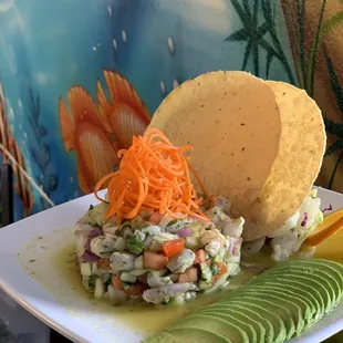 Tostada de ceviche camarón verde with side salad and avocado