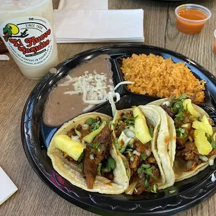 Pastor tacos con arroz y frijoles.