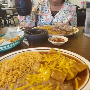 a woman sitting at a table with a plate of mexican food