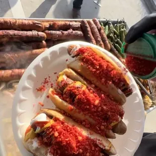 they are bacon rapped and the toppings are mayo, ketchup, mustard, hot cheetos, grilled onion with bell pepper and jalapeños.