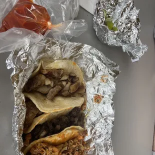 4 tacos, two are carnitas, one is buche and another is asada