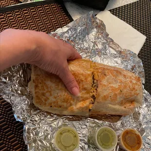 a hand holding a burrito