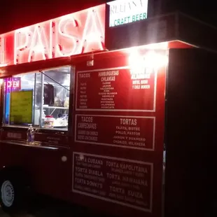a food truck with a neon sign