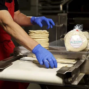 a person wearing blue gloves and a red apron