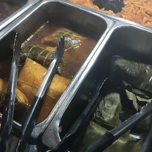 These are Puerto Rican tamales called "pasteles" to the left and regular tamales to the right.