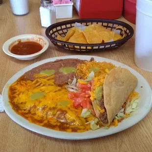 a plate of mexican food and a basket of tortillas