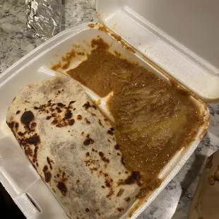 Burrito with what looks like canned refried beans next to it. Food was extremely cold.