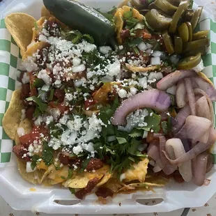 Al Pastor Nachos with grilled onions and slices jalapeños added. And yes, they did it right with pineapple included