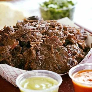a plate of meat and sauces