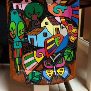 Bright bit of artisanry on a shelf near register.