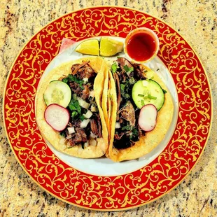 Barbacoa(lamb) tacos with lime wedges and chile salsa