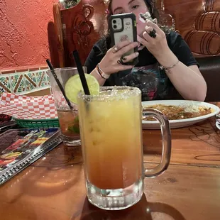 a woman taking a picture of a drink